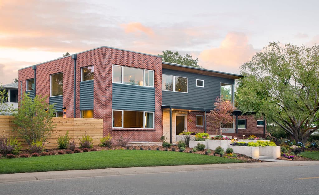 A front view of the Sunset Idea House covered in brick and numerous windows on both house floors.