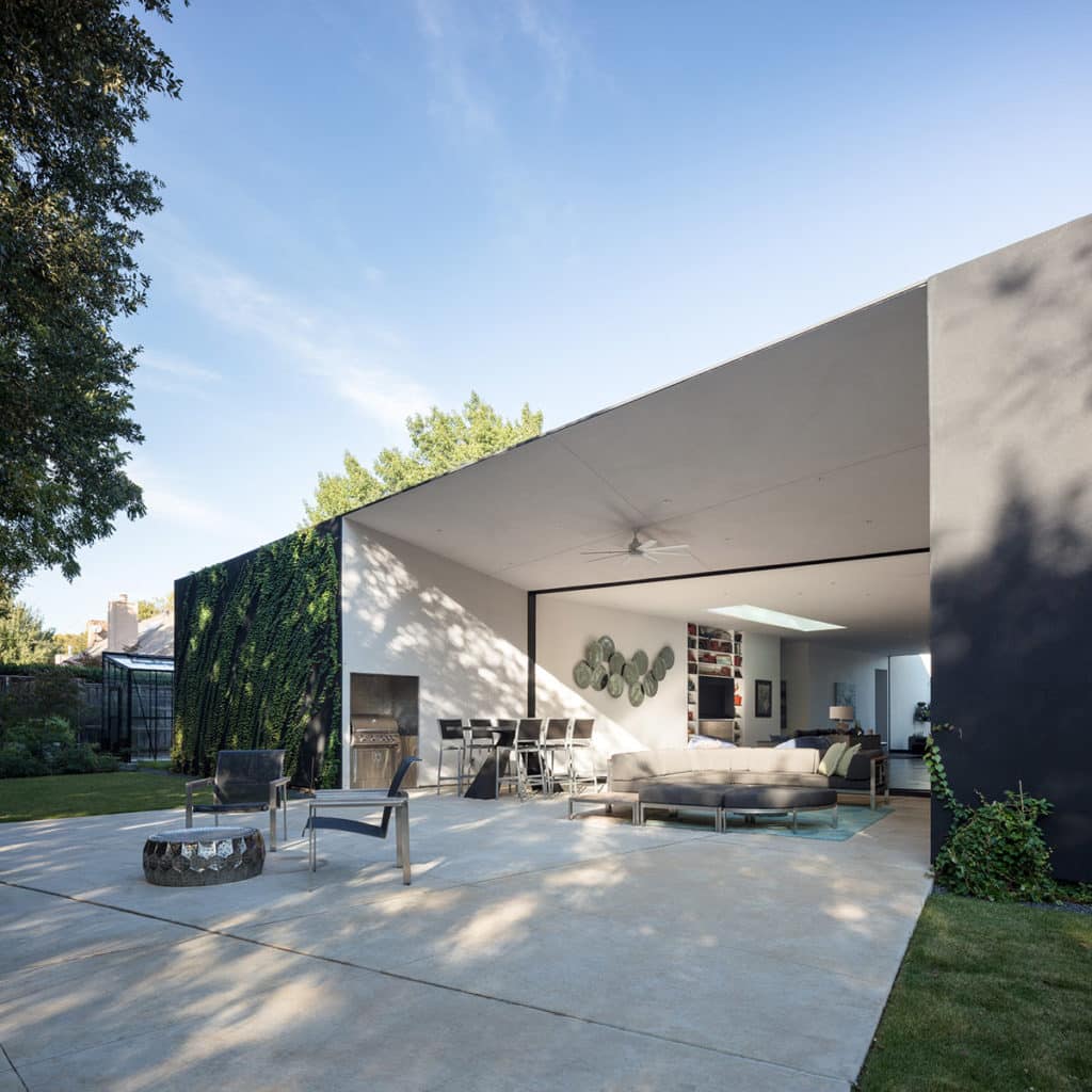 The patio and covered, outdoor seating blends with the indoor living area when the multi-slide doors are fully open.