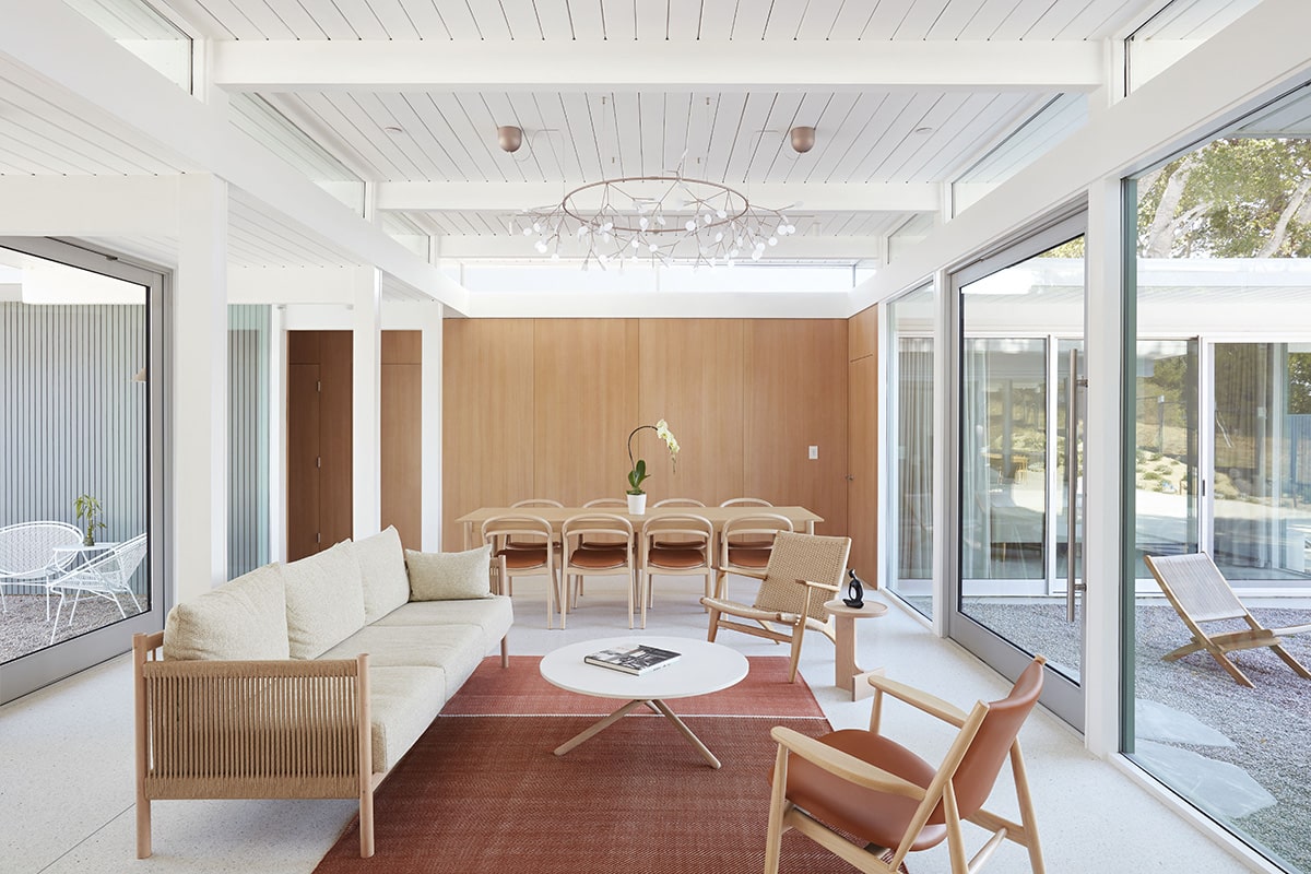 A view inside the atrium of two seating areas with glazing on both sides of the space.