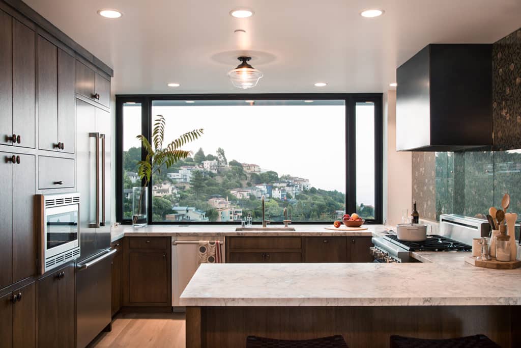 A massive window frames the landscape, making it a part of the kitchen.