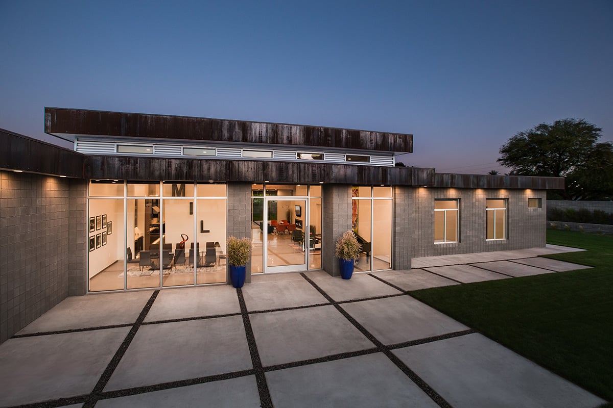 An outdoor view of the home’s front that uses Western Window Systems’ glass walls, pivot door, and operable windows for maximum energy efficiency.