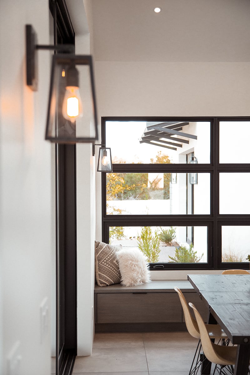 A wall of fixed and awning windows behind the dining room table.