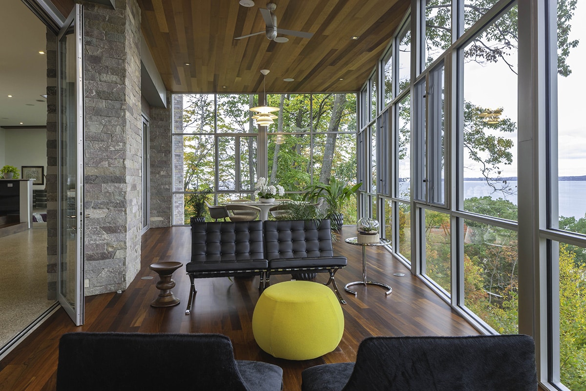 Huge hinged doors open the great room to the sun-drenched enclosed porch.