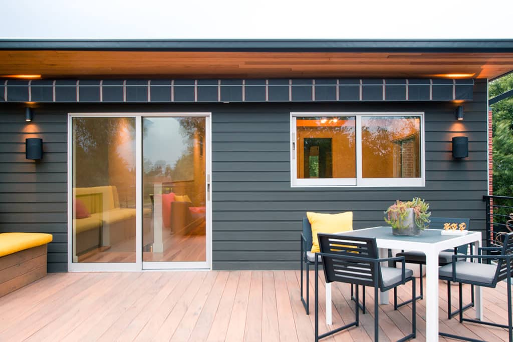 A sliding glass door and sliding window lead to the outdoor dining area.
