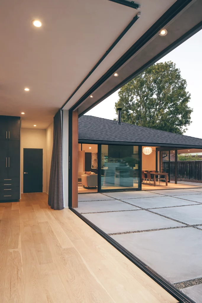 This view of the main living area from inside the master bedroom shows how two 90-degree multi-slide doors seamlessly blend the indoors with the outside.