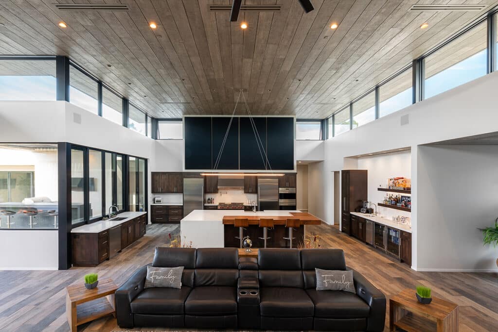 A view of the kitchen full of windows and sliders from the living room.