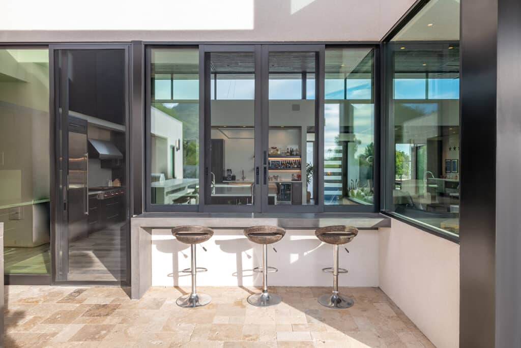 The sliding window and door screens are closed, viewed from the backyard.