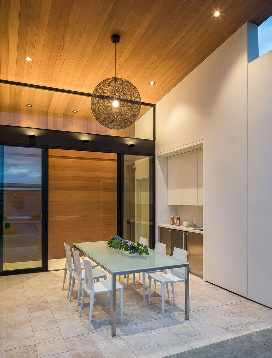 The outdoor dining room with a bar and sliding glass doors leading to the hallway.