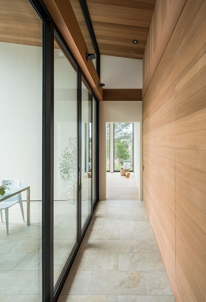 A view of the hallway next to the dining room with sliding doors on one side and cedar planking on the other.