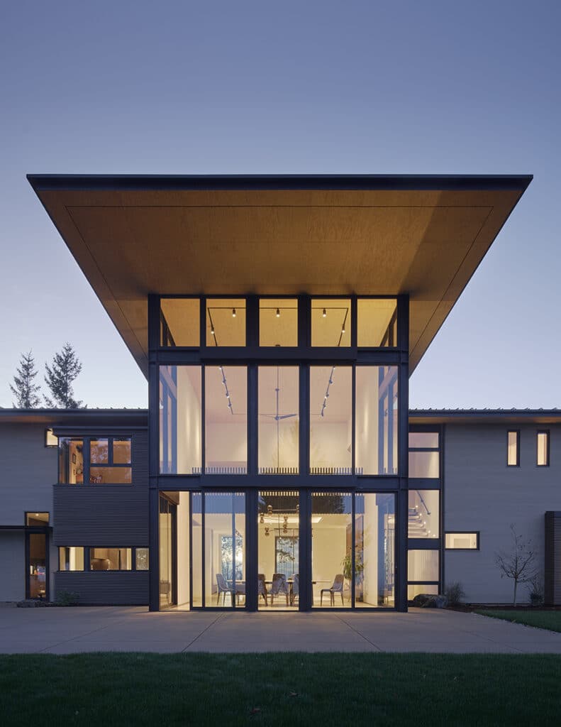 The floor-to-ceiling window wall illuminates the backyard at night when the dining room lights are on.